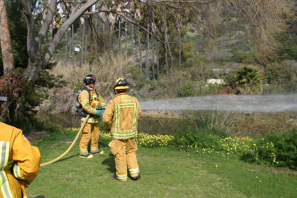 LAGUNA BEACH, CA - FEB 19: Firefighter recruit sprays water during fire fighting drills at the local Fire Department training area on February 19, 2009 in Laguna Beach, California. Fire Fighters training to use fire equiptment. 