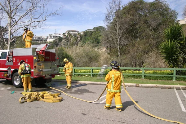 2009年2月19日 カリフォルニア州ラグナビーチの地元消防訓練場で 消防士が消火訓練中にスプレー水を募集した 消防士訓練消防設備を使用する訓練 — ストック写真