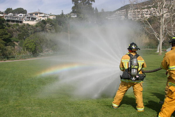 LAGUNA BEACH, CA - FEB 19: Firefighter recruit sprays water during fire fighting drills at the local Fire Department training area on February 19, 2009 in Laguna Beach, California. Fire Fighters training to use fire equiptment. 