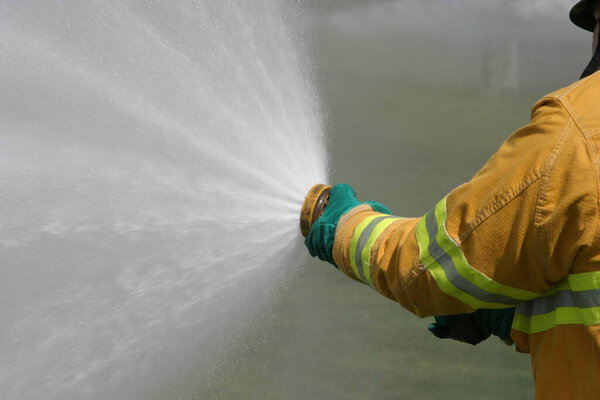 LAGUNA BEACH, CA - FEB 19: Firefighter recruit sprays water during fire fighting drills at the local Fire Department training area on February 19, 2009 in Laguna Beach, California. Fire Fighters training to use fire equiptment. 
