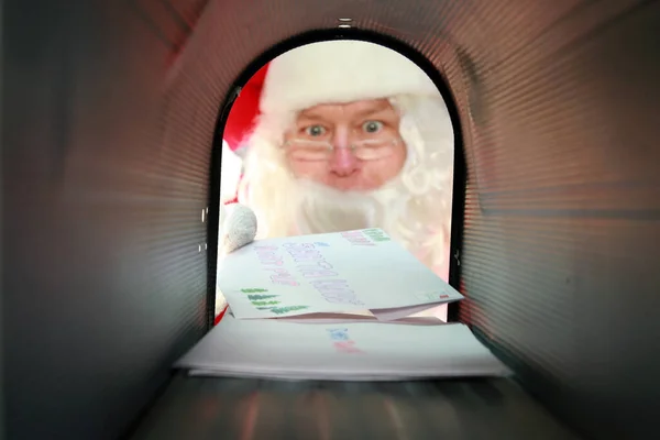 Santa Claus mail box. Santa Claus prepares to Mail or Receives a Red Gift Box in his mail box. Christmas Presents by mail. Santa Claus collects his mail. Santa Claus checks his mail box for letters and request for Christmas Gifts.