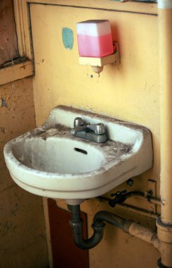 Eski kirli banyo. Pis lavabo. Eski paslı beyaz seramik lavabo. Kirli eski banyoya takılmış lavabo. Ev işleri işte. Eski terk edilmiş bina banyosu. Eski kirli tuvalet.. 