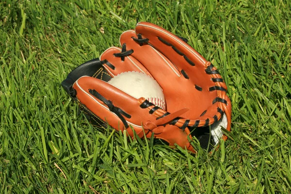 baseball. baseball game. catchers mit. baseball glove and baseball lay in a grass field. Baseball is America's number one sport.