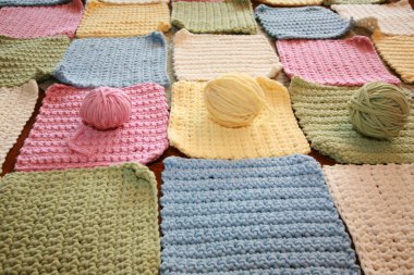 Tığ işi. Pamuk ipliklerle örgü örmek. Pamuk ipliğiyle tığ işi. Masada tığ işi desenleri var. Tığ işi, yakın plan. Tığ işi kalın iplik hobisi. Örgü kancasıyla farklı renklerde iplikler. Örgü, tığ işi malzemeleri. İplik.