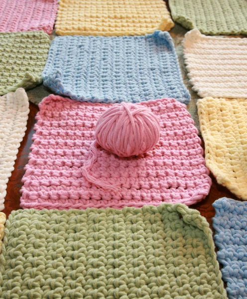 Tığ işi. Pamuk ipliklerle örgü örmek. Pamuk ipliğiyle tığ işi. Masada tığ işi desenleri var. Tığ işi, yakın plan. Tığ işi kalın iplik hobisi. Örgü kancasıyla farklı renklerde iplikler. Örgü, tığ işi malzemeleri. İplik.