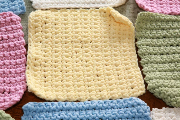 Tığ işi. Pamuk ipliklerle örgü örmek. Pamuk ipliğiyle tığ işi. Masada tığ işi desenleri var. Tığ işi, yakın plan. Tığ işi kalın iplik hobisi. Örgü kancasıyla farklı renklerde iplikler. Örgü, tığ işi malzemeleri. İplik.