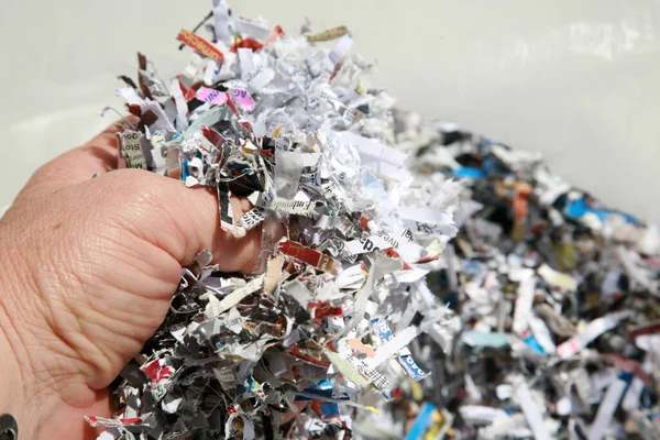 shredded paper. Anti-identity theft shredded paper. Shredding sensitive documents and information helps control Identity Theft. confetti shredded paper and documents. Confetti Shredded paper in a recycle trash can. keep safe from Identity Fraud.
