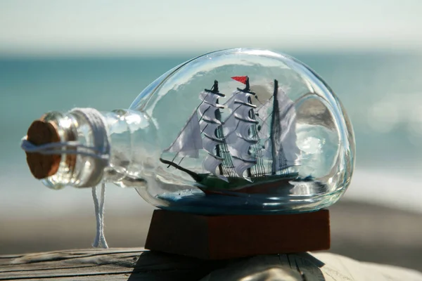 Ship in a Bottle. Bottle with ship inside lying on the beach. Ship in a bottle lost at sea. small ship in the glass bottle. Lost at sea. A pirate ship trapped in bottle for all of eternity. pirate ship in a bottle. merchant ship in a bottle.