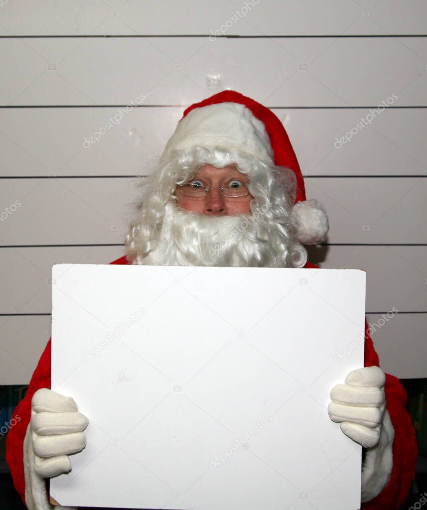 Santa Claus Mug Shot. Santa Claus Christmas. Santa Claus Mug Shot. Santa is arrested and his Mug Shot photo taken. Santa Claus arrested at Christmas. Santa Claus has his Mug Shot. Santa is Scared. Santa holds a blank booking placard. room for text