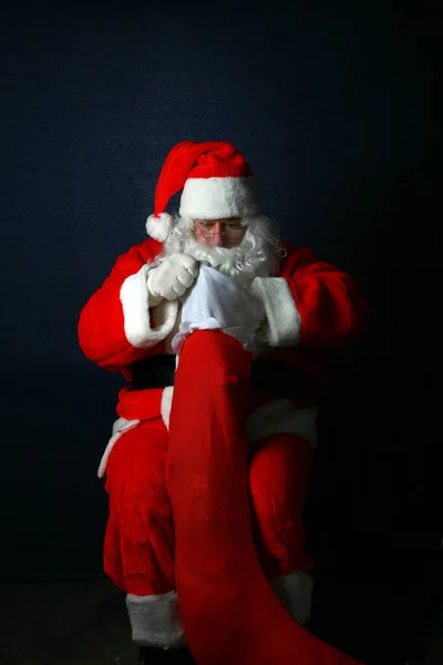 Świąteczna Skarpeta Święty Mikołaj Wypełnia Świąteczne Pończochy Prezentami Smakołykami Wesołych — Zdjęcie stockowe