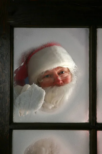 Święta Święty Mikołaj Wygląda Przez Okno Śniegiem Święty Mikołaj Wyciera — Zdjęcie stockowe