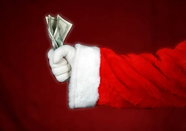 圣诞节钱 圣诞老人拿着钱 圣诞节的手上塞满了现金 圣诞老人的手拿着红底钱 把钱交出来圣诞节钱 圣诞礼物圣诞雄鹿 现金是国王 圣诞老人给了圣诞节的钱 — 图库照片