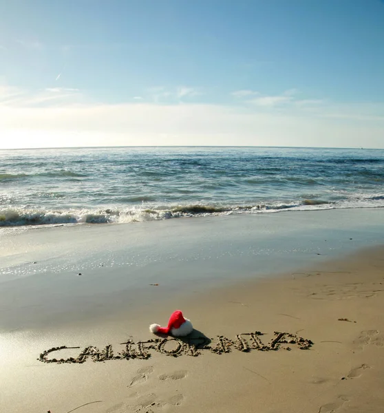 Kalifornii Słowo Kalifornia Napisane Piasku Plaży Santa Claus Kapelusz Fale — Zdjęcie stockowe