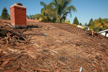 Çatı tamiri. Eski çatı tamiri ve yeni bir ev kiremitleri. Çatı tamiri. İnşaat işçisi yeni bir çatı kuruyor. Hasarlı kiremitleri değiştiren çatıcılar. Ev Çatı Tamiri. 