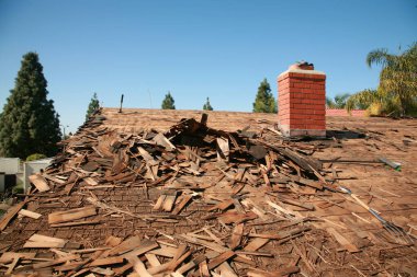Çatı tamiri. Eski çatı tamiri ve yeni bir ev kiremitleri. Çatı tamiri. İnşaat işçisi yeni bir çatı kuruyor. Hasarlı kiremitleri değiştiren çatıcılar. Ev Çatı Tamiri. 