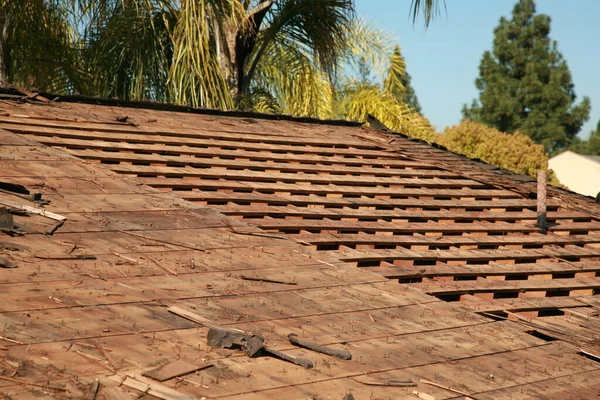 Roof Replacement. Roof repairs old roof replacement with new shingles of a home. Roof repair.  Construction worker installs a new roof. Roofers replacing damaged shingles. Home Roof Repair.