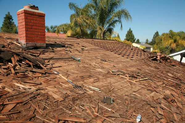 Roof Replacement. Roof repairs old roof replacement with new shingles of a home. Roof repair.  Construction worker installs a new roof. Roofers replacing damaged shingles. Home Roof Repair.