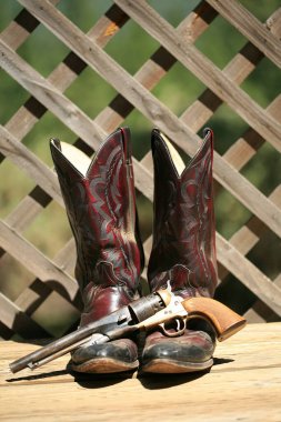 Cowboy Boots. Western Wear. Cowboy Boots, Cowboy Hat and Six Shooter Pistol. A pair of red leather western boots with a golden straw hat. Rustic western image of cowboy boots, cowboy hat, and Gun. decorative cowboy boots. Cowboy boots and hat. clipart