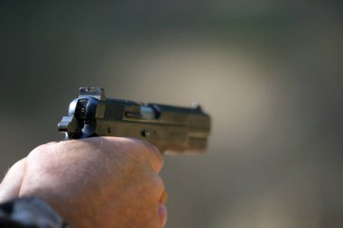 Silahı var. 45 kalibrelik bir tabanca. 45 'lik tabanca dışarıda ateşlenmiş. Amerika Anayasası 'nın 2. maddesini temsil ediyor. Çıplak silah kullanma hakkı. Sivil Özgürlükler. Kişisel koruma için. Yaşamın ve malın korunması. Silah Kontrol. 45 ACP kalibre otomatik tabanca. Colt 1911 