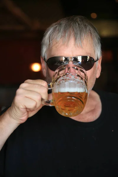 Beer. A man drinking beer. A Man Drinking A Mug Of Beer. Happy elegant man drinking beer.  man drinking beer from a beer mug. man with a glass of beer. man holds a beer glass. Man drinking beer in pub. brewery. hipster drink beer. Happy birthday.