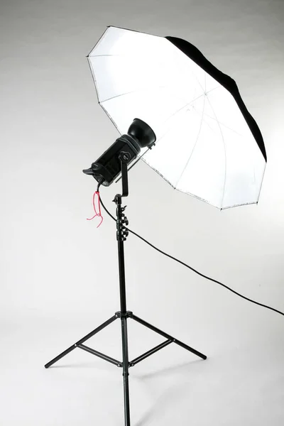 Studio Lights. Studio Lighting equipment. white umbrella lighting. White Soft Box. Photo Studio Lights. Isolated on white. Room for text. a single studio flash on a tripod. Studio Flash is used in photography. professional photo equipment. lights.