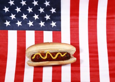 Sosisli sandviç. 4 Temmuz Hot Dog. Barbekü Partisi Yemeği. Amerikan bayrağı taşıyan vatansever bir sosisli sandviç. 4 Temmuz 'da Amerika Birleşik Devletleri' nde Bağımsızlık Günü 'nü kutluyoruz. Bağımsızlık Günü sosislisi. Amerikan Bayrağında Ketçap ve Hardallı Sosisli.