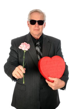 Sevgililer Günü. Romantik Adam. Sevgililer Günü Hediyesi. Sevgililer Günü için çiçekler. Sevgililer Günü için çikolatalar. Romantik sürpriz. Beyaz üzerine izole edilmiş. Mesaj için yer var. Adamın elinde bir düzine gül ve şeker var. Romantik erkek arkadaş. Yakışıklı adam kırmızı kalbi tutuyor..