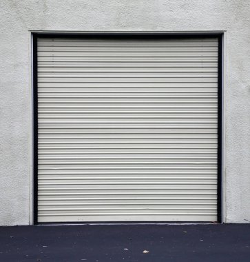 Kapıyı Yuvarla. Garaj kapısı. Depo kapısı. Genel Yuvarlanma Kapısı. Garaj ya da Kapısı Yuvarlanan Depo. Geniş çelik güvenlik kapısı olan bir bina girişi. Los Angeles California ya da dünyanın herhangi bir yerinde güvenlik için kapılar kullanılıyor.. 