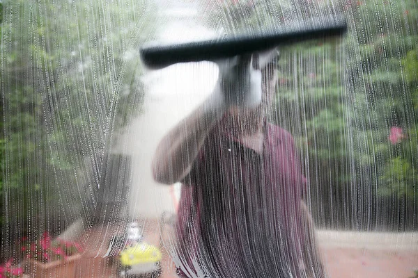 Window Washing. Window Cleaning. Window Cleaner. Window Cleaning Service. a professional window cleaner soaps and squeegees a window clean. Window cleaner using a squeegee to wash a window. man cleaning a window. Professional Window Cleaning Service.