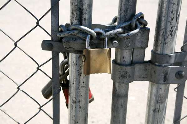 Pad Lock. A pad lock on a gate. Locks help keep things closed and safe. Locks help secure locations and property from bad people and strangers. A gate closed with a padlock. keep out. do not enter. private property. Area 51. UFO Research Site. Unsafe