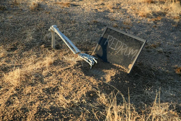 Crime Scene. Crime Scene. A skeleton arm reaches out of a grave to type a clue on a computer. Murder scene. Forensic expert discovering dead body buried in desert sand. police investigation of an cold case murder crime scene. REDRUM REDRUM REDRUM