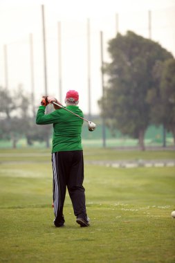 Golf mü? Golf oynuyordum. Vuruyorum. Golf oynayan bir adam. Golf topu koyan bir adam. Golf sopası ve top çimen konseptinde. Golf sahasında golf sopalarıyla golf topları ilk kısa devre için hazır. Sabah, güzel güneş ışığıyla. Golf oynanır. 