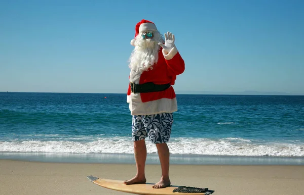 산타클로스가 서핑을 크리스마스 시간이야 산타클로스는 크리스마스 이후에 보드를 매달린다 선글라스 — 스톡 사진