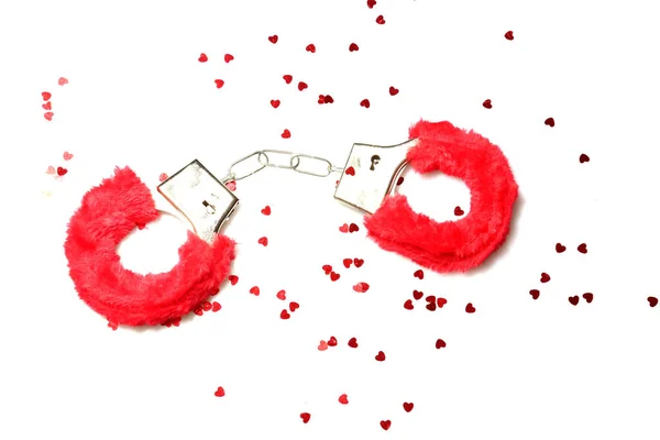 Hand Cuffs. Love Cuffs. Furry Hand Cuffs. Kinky Hand Cuffs.Red erotic fur lined handcuffs. Hands in captivity. Red furry  handcuffs. Isolated on white. Room for text. Clipping Path. Adult games and toys. BDSM, fetish wear and kinky sex toy. bondage.