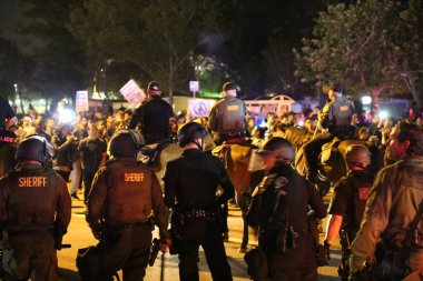 Costa Mesa, CA - 28 Nisan 2016: Cumhuriyetçi başkan adayı Donald Trump 'ın protestocuları, polis kalabalığı kontrol ederken sokaklardaki ayaklanmalar ve Costa Mesa Fuarı, CA' da düzenlenen mitingde tutuklama.