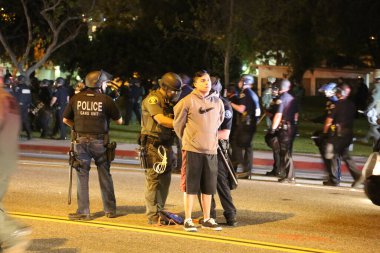 Costa Mesa, CA - 28 Nisan 2016: Cumhuriyetçi başkan adayı Donald Trump 'ın protestocuları, polis kalabalığı kontrol ederken sokaklardaki ayaklanmalar ve Costa Mesa Fuarı, CA' da düzenlenen mitingde tutuklama.