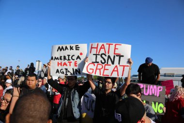 Costa Mesa, CA - 28 Nisan 2016: Kosta Mesa CA 'da düzenlenen mitingde protestocular cumhuriyetçi başkan adayı Donald Trump' ın destekçilerini engellemeye, slogan atmaya ve slogan atmaya çalıştılar. Başkan Donald Trump. Tanrı Amerika 'yı korusun.. 