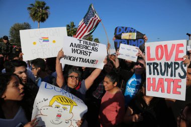 Costa Mesa, CA - 28 Nisan 2016: Kosta Mesa CA 'da düzenlenen mitingde protestocular cumhuriyetçi başkan adayı Donald Trump' ın destekçilerini engellemeye, slogan atmaya ve slogan atmaya çalıştılar. Başkan Donald Trump. Tanrı Amerika 'yı korusun.. 