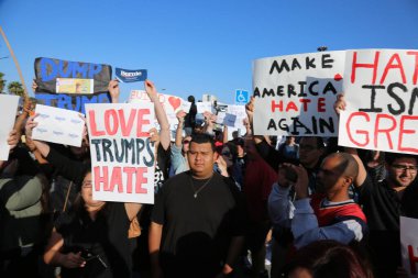 Costa Mesa, CA - 28 Nisan 2016: Kosta Mesa CA 'da düzenlenen mitingde protestocular cumhuriyetçi başkan adayı Donald Trump' ın destekçilerini engellemeye, slogan atmaya ve slogan atmaya çalıştılar. Başkan Donald Trump. Tanrı Amerika 'yı korusun.. 