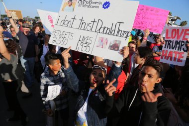 Costa Mesa, CA - 28 Nisan 2016: Kosta Mesa CA 'da düzenlenen mitingde protestocular cumhuriyetçi başkan adayı Donald Trump' ın destekçilerini engellemeye, slogan atmaya ve slogan atmaya çalıştılar. Başkan Donald Trump. Tanrı Amerika 'yı korusun.. 