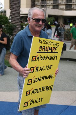 Costa Mesa, CA - 28 Nisan 2016: Kosta Mesa CA 'da düzenlenen mitingde protestocular cumhuriyetçi başkan adayı Donald Trump' ın destekçilerini engellemeye, slogan atmaya ve slogan atmaya çalıştılar. Başkan Donald Trump. Tanrı Amerika 'yı korusun.. 