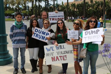 Costa Mesa, CA - 28 Nisan 2016: Kosta Mesa CA 'da düzenlenen mitingde protestocular cumhuriyetçi başkan adayı Donald Trump' ın destekçilerini engellemeye, slogan atmaya ve slogan atmaya çalıştılar. Başkan Donald Trump. Tanrı Amerika 'yı korusun.. 