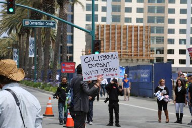 Costa Mesa, CA - 28 Nisan 2016: Kosta Mesa CA 'da düzenlenen mitingde protestocular cumhuriyetçi başkan adayı Donald Trump' ın destekçilerini engellemeye, slogan atmaya ve slogan atmaya çalıştılar. Başkan Donald Trump. Tanrı Amerika 'yı korusun.. 