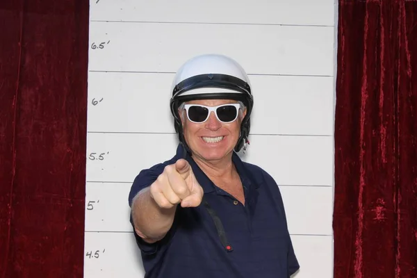 Photo Booth. Mug Shot Photo Booth. A Criminal is arrested and has his photo taken. Booking Photo. Police mug shots of a male criminal and his dog, standing in front of a Mug Shot Wall.  Under arrest. mug shot of man in Police Motorcycle Helmet.