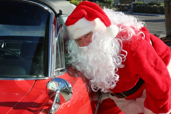 圣诞节 圣诞老人 圣诞老人用他的汽车摆姿势要他的肖像 圣诞老人准备好迎接圣诞节了 圣诞老人在度假 圣诞老人驾驶着他的红热的棒子车 红车圣诞老人 送圣诞礼物 — 图库照片