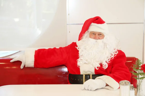 Christmas. Santa Claus. Restaurant. Diner. Lunch Time. Dinner. Cafe. Santa Claus is sitting in a cafe. Santa Claus is waiting for Lunch. Santa Claus is waiting for dinner. Christmas diet. Enjoy healthy Christmas dinner. Healthy Christmas restaurant.