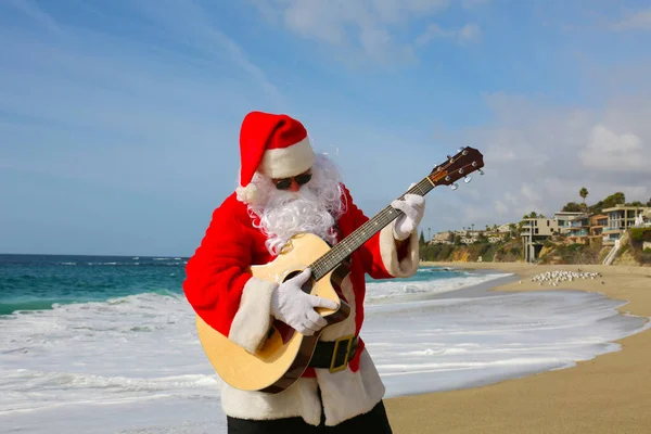 圣诞节 圣诞老人 圣诞老人 圣诞老人在海滩上弹奏吉他 音乐圣诞老人 英俊的胡子圣诞老人独奏家弹吉他 圣诞老人玩得很开心 把吉他弹奏给大家听 圣诞快乐 圣诞歌曲 — 图库照片