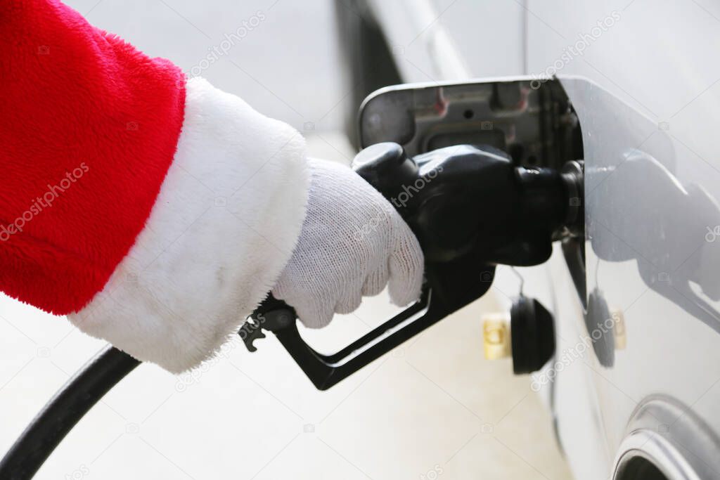 Christmas. Santa Claus. Gas Station. Santa Claus Fills his Truck up with Gasoline. Santa Claus getting a fill up at a Gas station. Gasoline refueling. Fill the Truck or car with fuel. Car fill up with gasoline at a gas station. Gas station pump. 
