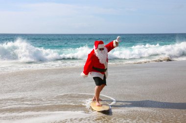 Noel Baba 'da sörf. Noel zamanı. Noel tatili. Noel Baba 'da sörf. Sörf tahtası. Sıkı tutun. Noel Baba tatildeyken dalgalarda sörf yapar. Noel arifesinden önce Noel Sörfleri. Noel Baba ve sörf tahtası. Noel Baba sörf tahtasında sörf yapıyor. Sörfler yukarı.