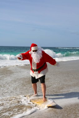 Noel Baba 'da sörf. Noel zamanı. Noel tatili. Noel Baba 'da sörf. Sörf tahtası. Sıkı tutun. Noel Baba tatildeyken dalgalarda sörf yapar. Noel arifesinden önce Noel Sörfleri. Noel Baba ve sörf tahtası. Noel Baba sörf tahtasında sörf yapıyor. Sörfler yukarı.
